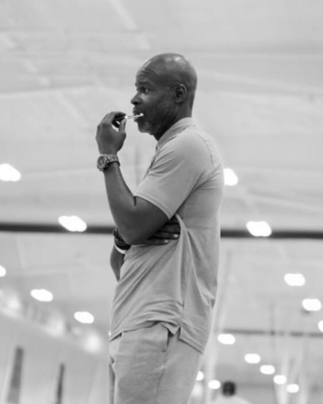 Coach Quentin Demeritte, TRUE BLUE 2030 head coach, standing courtside with a whistle